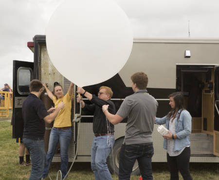 Pat Market (middle) prepares a weather balloon for launch during the South Farm Showcase.