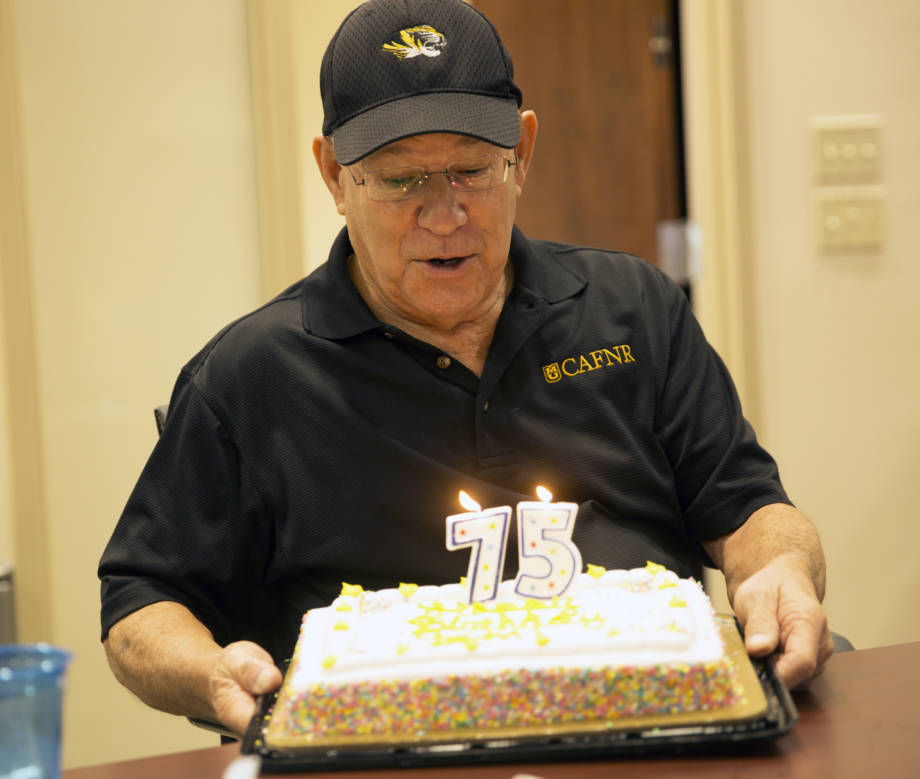 CAFNR Dean Tom Payne blows out the candles on his cake during a recent celebration of his 75th birthday. Photo by Aaron Duke. 
