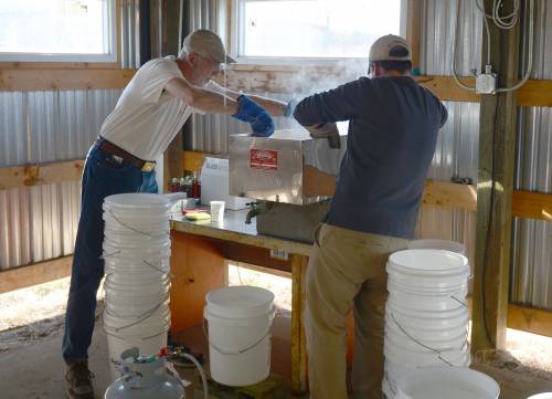 Knapp and Hank Stelzer, associate teaching professor and state forestry extension specialist, prepare to move the maple syrup from the smaller evaporator to bottles.